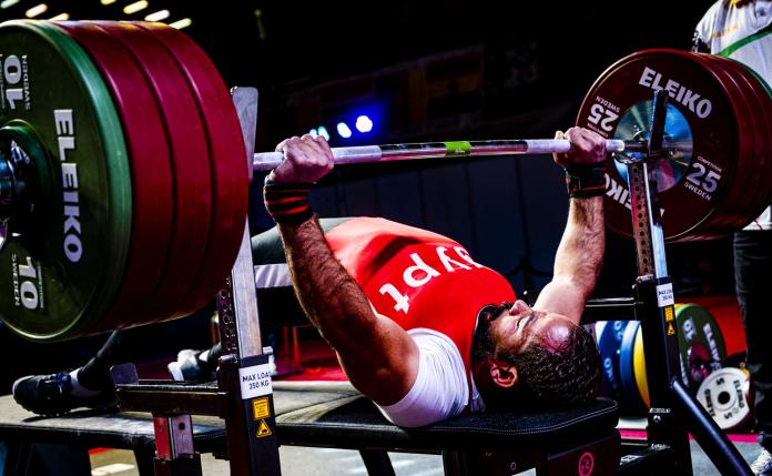 A man lifting weight in a Para powerlifting competition