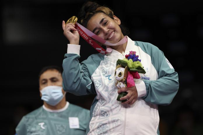 Guljonoy Naimova smiles as she celebrates with her gold medal