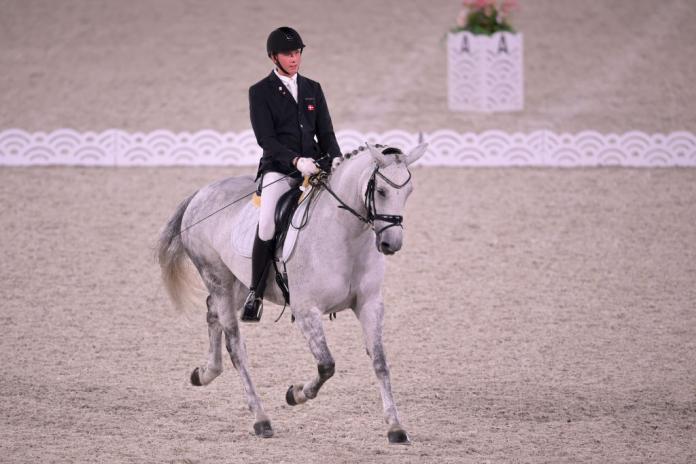 Tobias Jorgensen, a Para equestrian athlete from Denmark, rides a white horse at the Tokyo 2020 Paralympics.