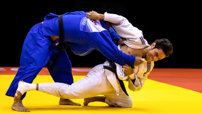 two male judokas fighting on the mate