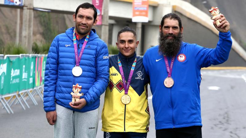 three male Para cyclists with their medals