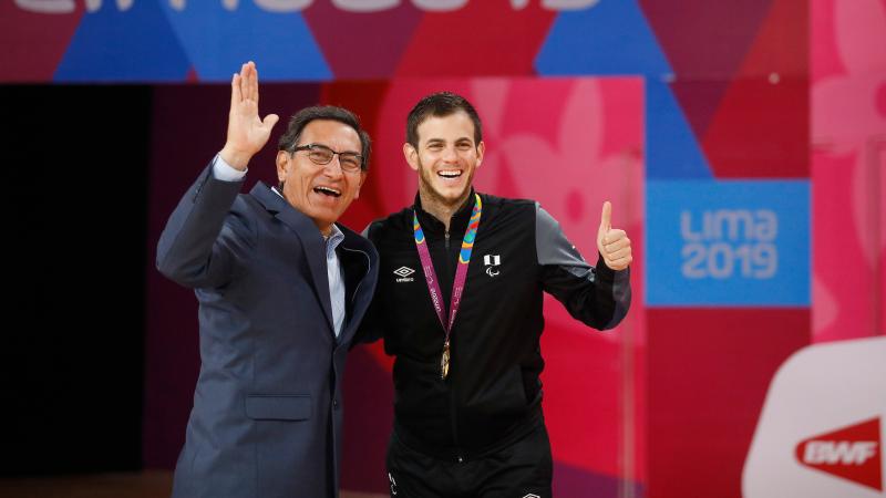 two men giving a thumbs up on the podium