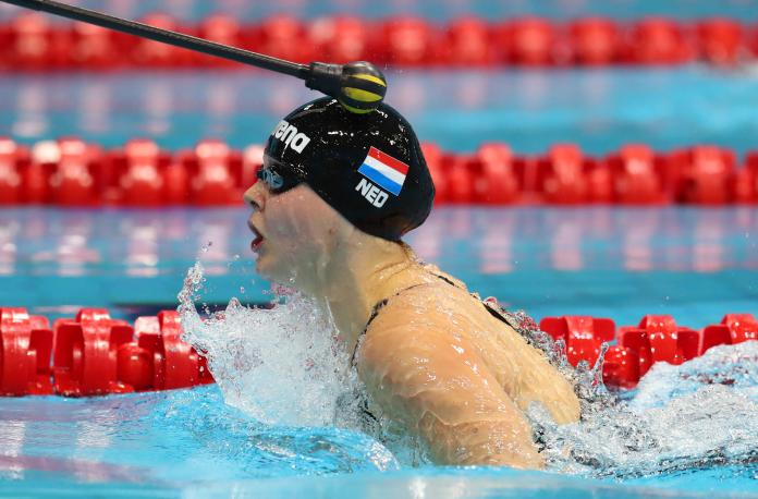 a female vision impaired swimmer is tapped on the head during breaststroke