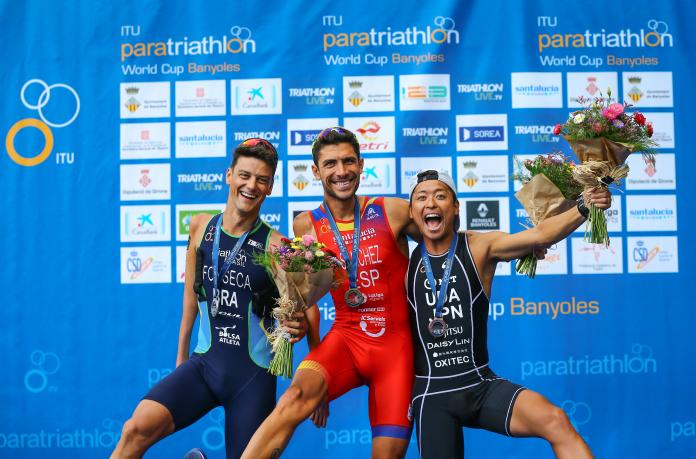Three male Para triathletes have fun posing for a podium photo