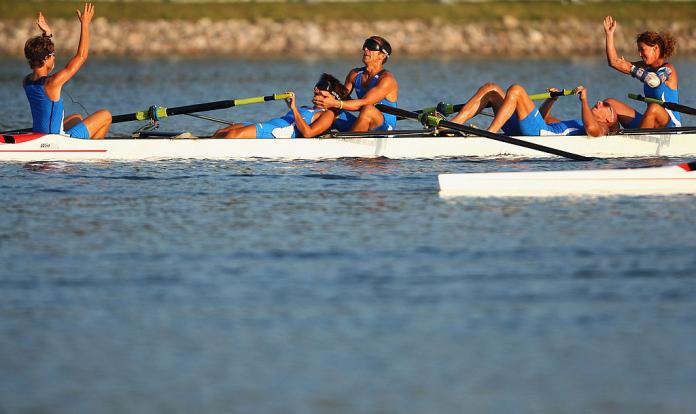 Italian mixed coxed four crew celebrate in exhaustion after winning gold