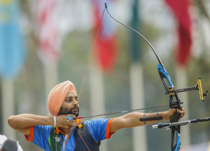 Indian male archer pulls prepares to shoot his bow and arrow