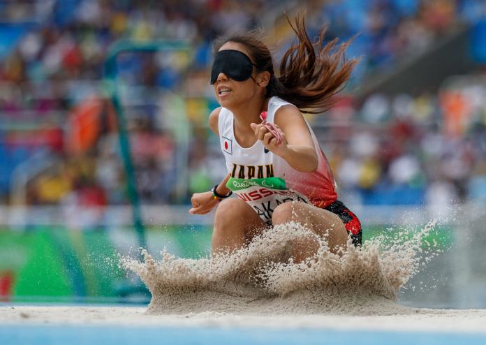 Japanese vision impaired long jumper falls on the sand after her jump