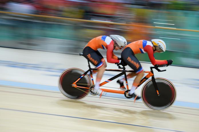 Dutch tandem track cyclists riding in a velodrome