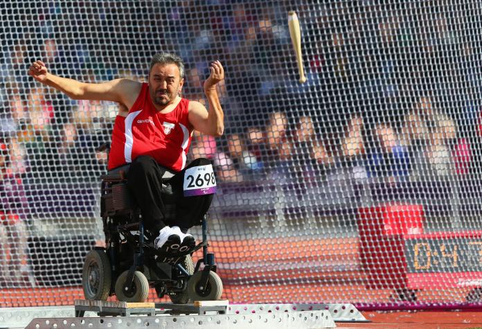 Athlete in a wheelchair throws the club