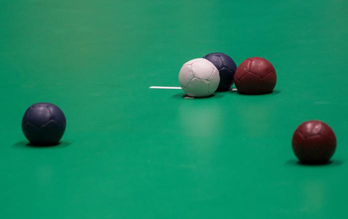 Red, blue and white boccia balls on the ground