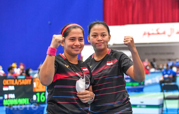 Two Indonesia women's players pose for photo after victory