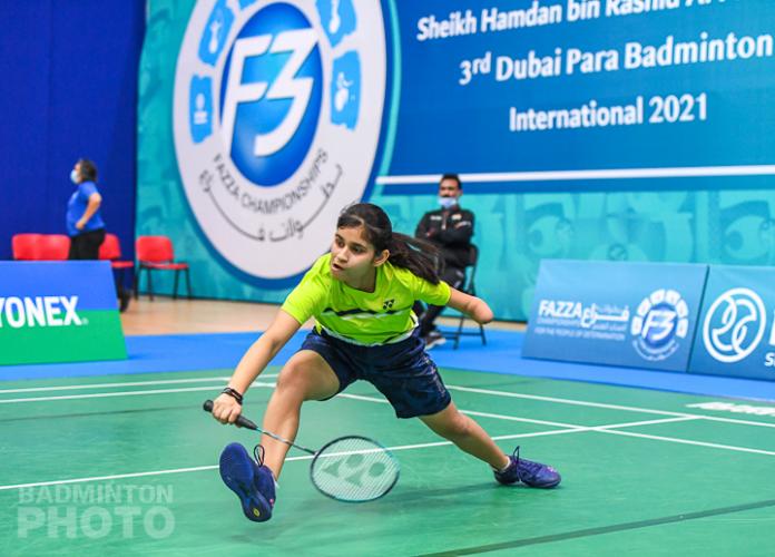 Young female badminton player with left arm impairment lunges for the shuttle
