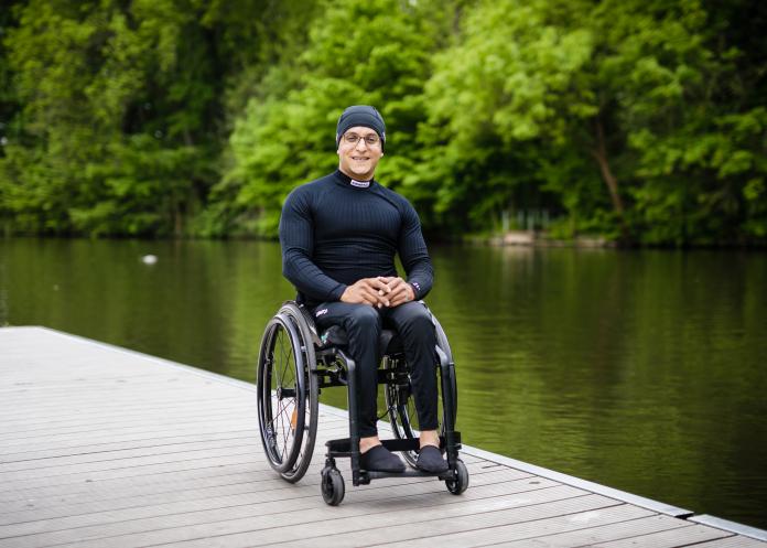Anas Al Khalifa in his wheelchair next to the river posing for the camera