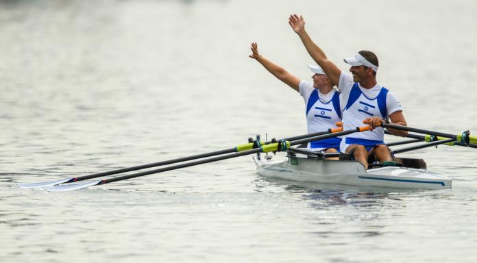 Male and female Israeli rowers wave to the crowd