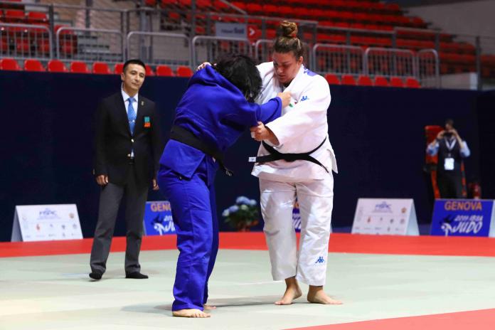 Two female blind judoka hold each other's uniforms
