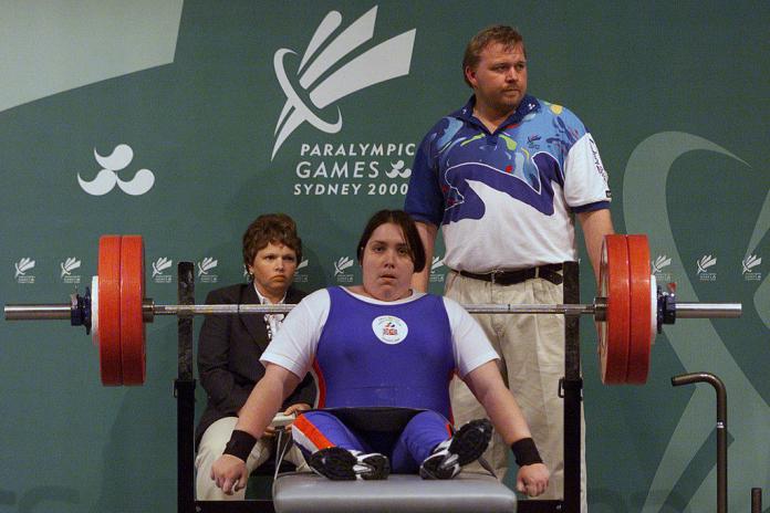 Female powerlifter rises from her bench