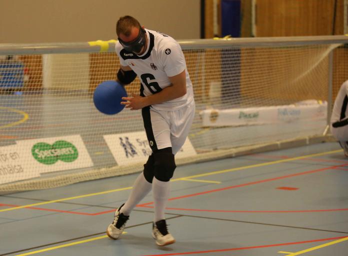 German male goalball player about to throw ball