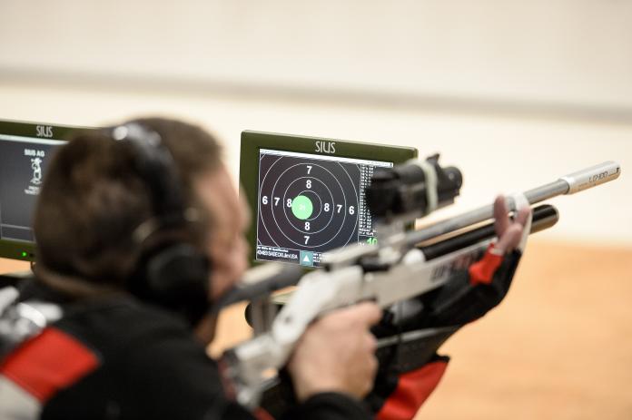 Electronic shooting target next to rifle athlete