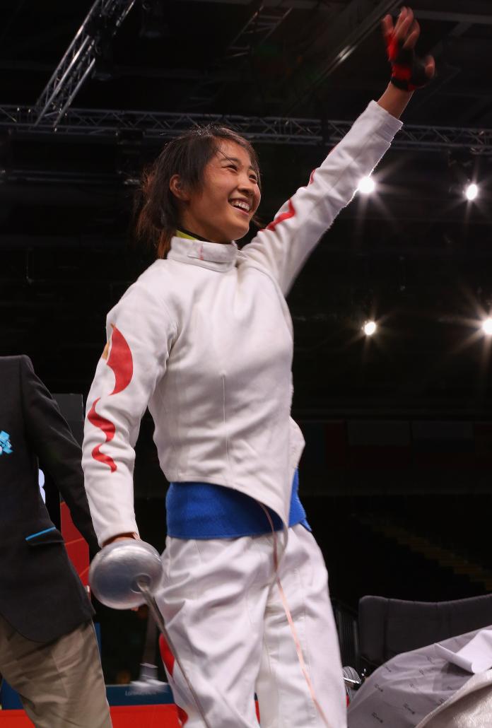 Chinese wheelchair fencer Rong Jing smiles and waves her hand in celebration