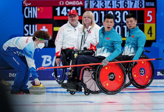 A Chinese wheelchair curlers reacts after releasing a stone