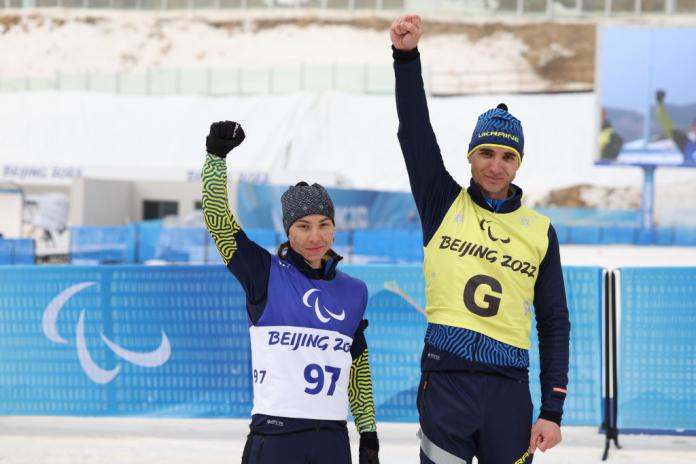 Oksana Shyshkova of Ukraine and her guide Andriy Marchenko pose after winning the Para Biathlon Women's Individual Vision Impaired at the Beijing 2022 Paralympic Winter Games.