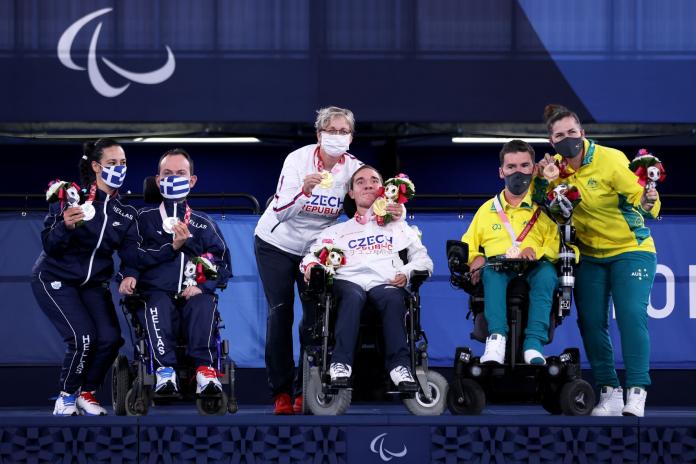 Three boccia athletes and their assistants take the podium at Tokyo 2020.