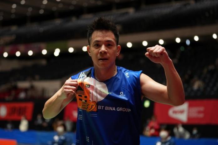 A male Para badminton player pumps his left fist