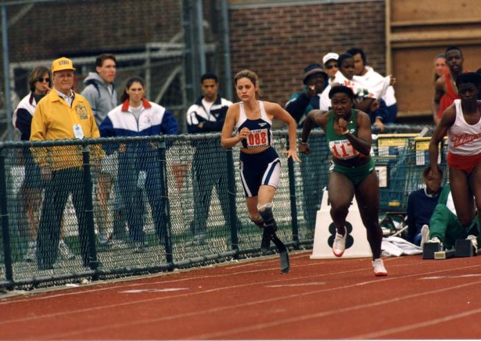 A female athlete with running blades races against other female athletes.