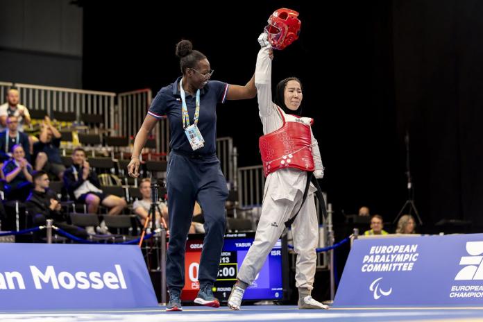 A female coach celebrates with a female Para taekwondo athlete