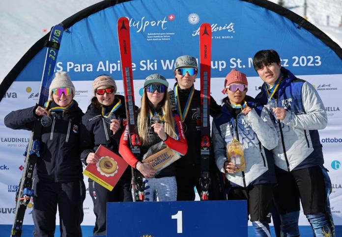 Six skiers pose for a photograph on the podium