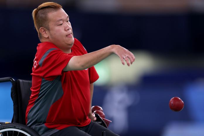 Yuk Wing Leung from Hong Kong, China throws a red boccia ball during competition.