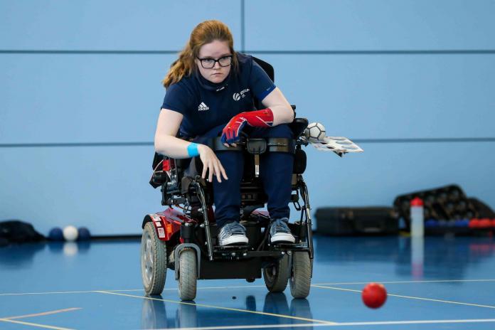 Claire Taggart, a female boccia athlete representing Great Britain, throws a red ball 