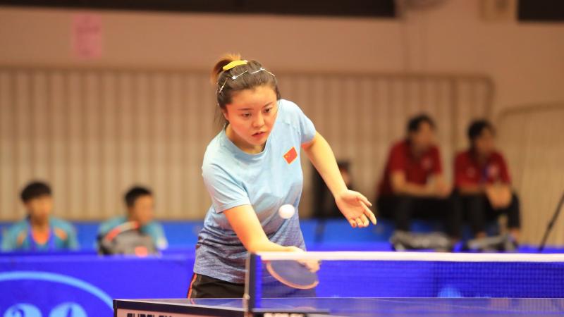 Chinese female table tennis player hits a return ball