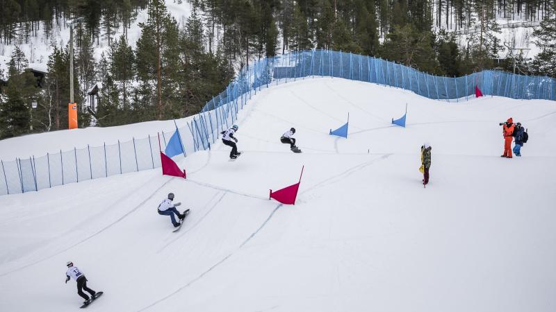 Four male snowboarders competing