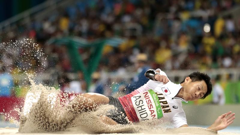 Japanese man completes long jump in sand
