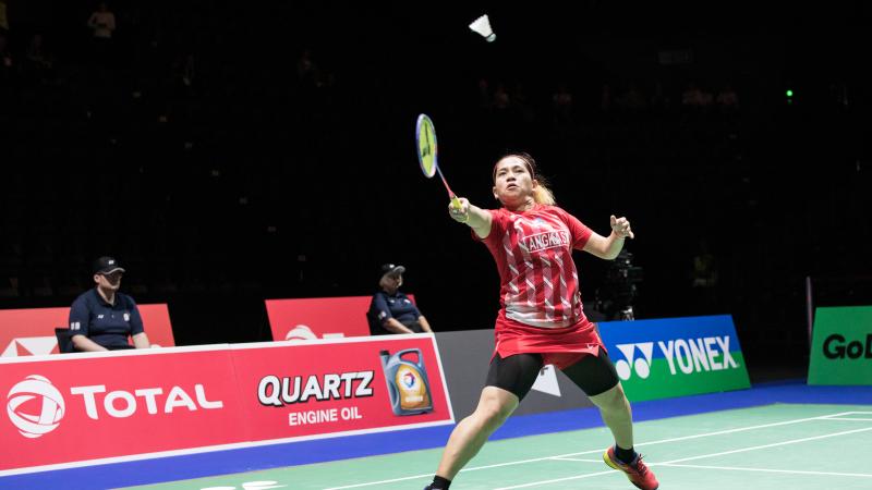 Indonesia female badminton player lunges for the shuttle