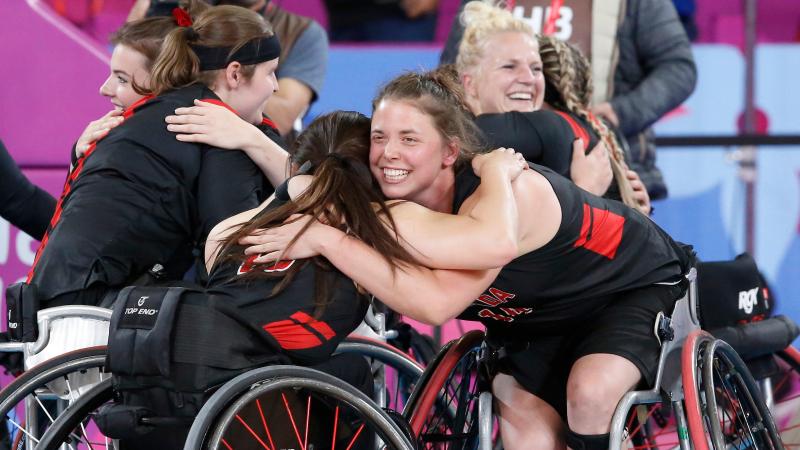 a group of female wheelchair basketball players hugging