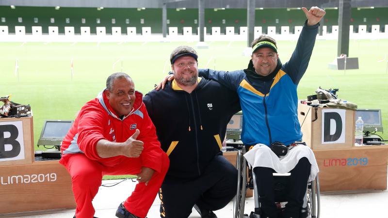 three male Para shooters with their arms around each other smiling