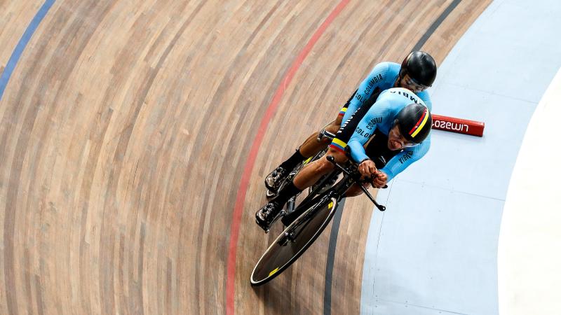 a male Para cycling tandem goes round a corner on the track