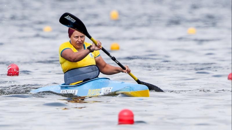 a female Para canoeist mid-stroke on the water