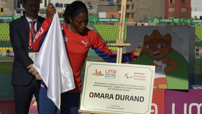 a female Para athlete unveils a plaque with her name on it