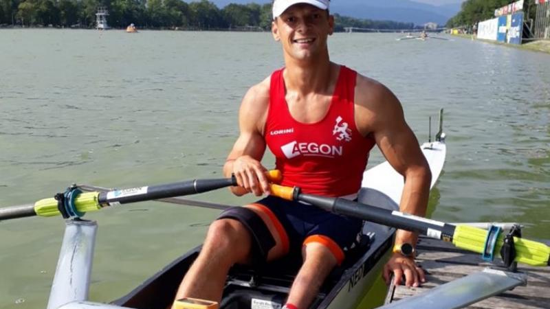 Dutch man sits in rowing boat and smiles