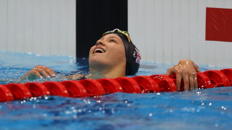 a female Para swimmer celebrates in the pool