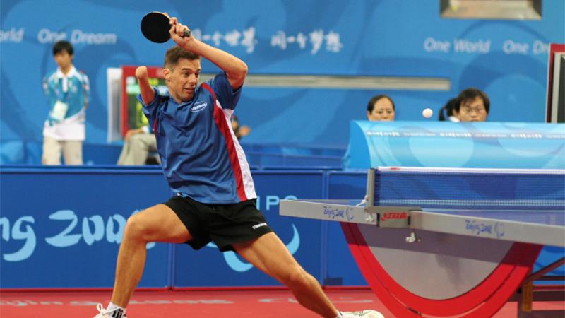 Man with right arm impairment hits a return shot in table tennis