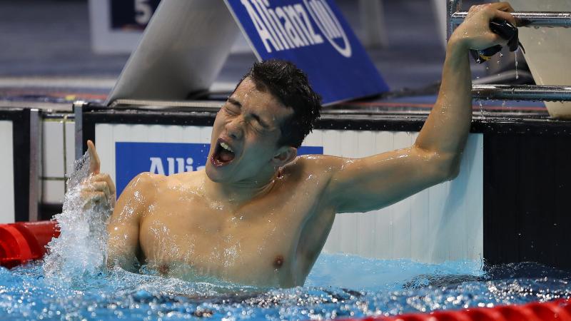 a male Para swimmer celebrates in the water