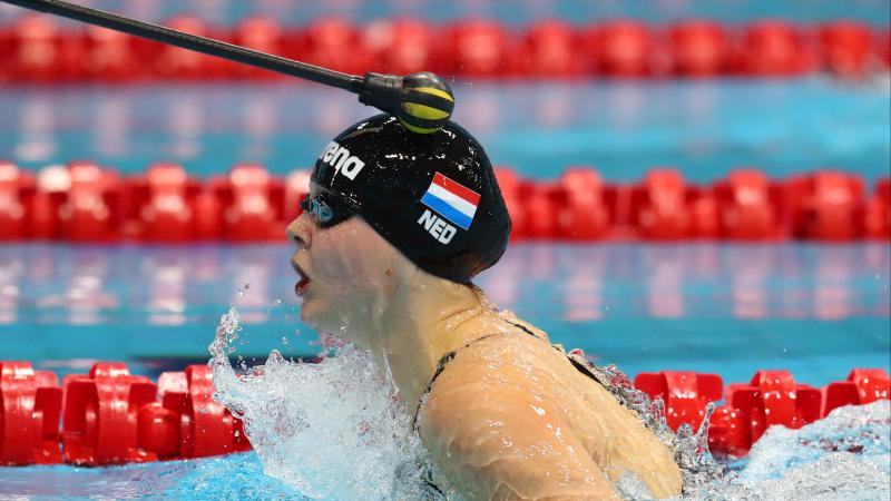 a female vision impaired swimmer is tapped on the head during breaststroke