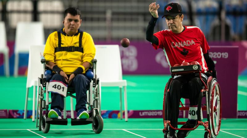 two male boccia players throwing a ball