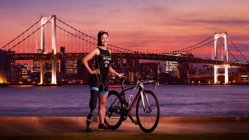 Japanese female triathlete poses with bridge in backdrop