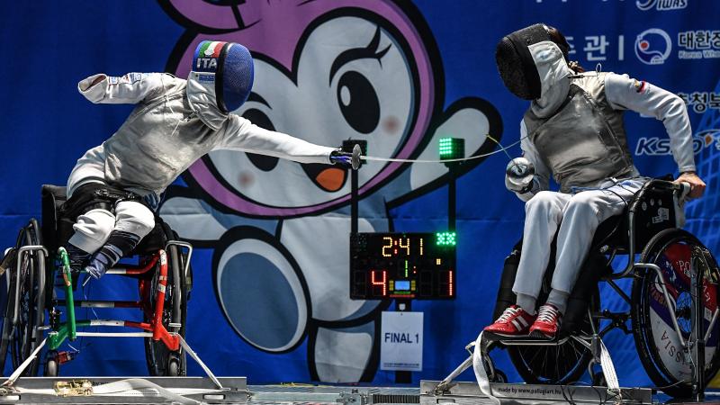 A wheelchair fencer lands a blow on her opponent
