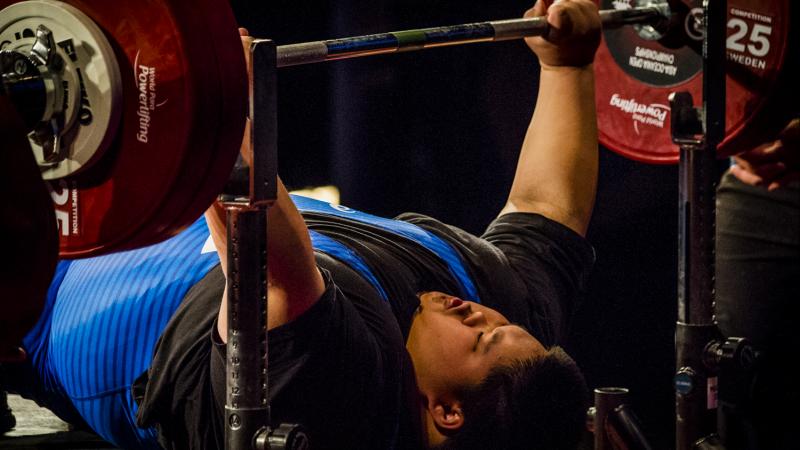 A male powerlifter lifting the bar